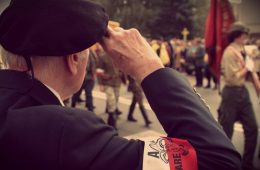 Obchody 60. rocznicy Powstania Warszawskiego we Włochach. Widok na salutującego Powstańca z opaską AK na ramieniu
