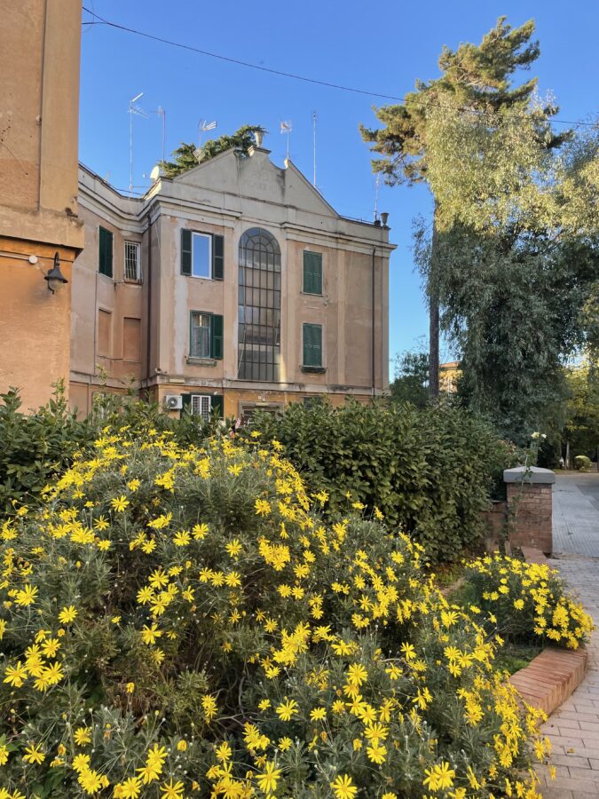 Garbatella Rzym widok na kamienicę i kwitnący krzew